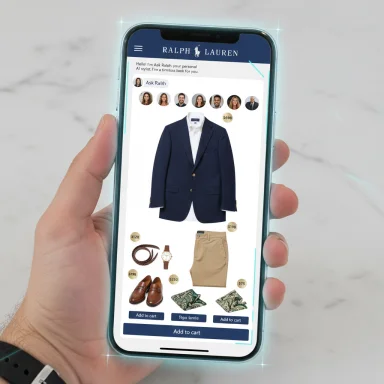 A hand holds a smartphone showing a Ralph Lauren online shop featuring a navy blazer and accessories.