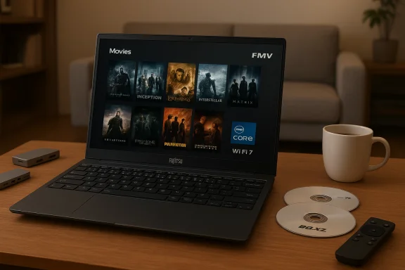 A Fujitsu laptop on a wooden table shows a movie library with posters, plus a mug and discs. A Fujitsu laptop on a wooden table shows a movie library with posters, plus a mug and discs.