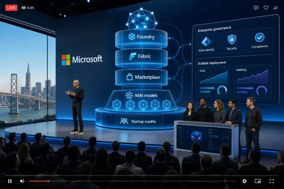 Microsoft conference stage shows a live speaker presenting a blue AI/cloud stack diagram to an audience.