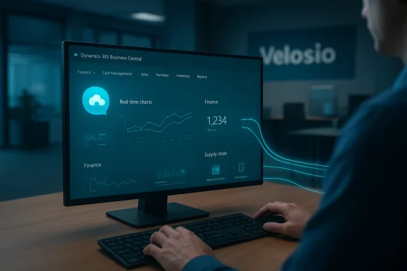A person uses a computer displaying teal-lit Dynamics 365 Business Central dashboards.